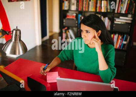 Hispanic woman working at home office Stock Photo