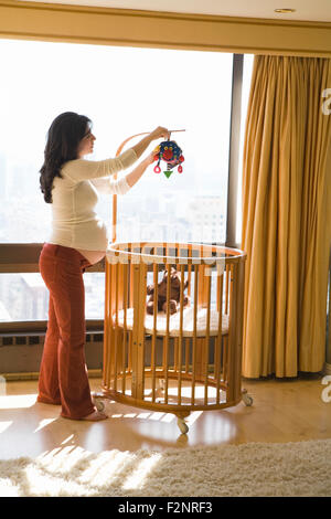 Pregnant woman decorating nursery Stock Photo