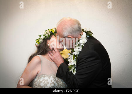 Older bride and groom kissing at wedding Stock Photo