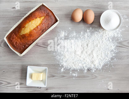 Delicious homemade golden brown plum cake surrounded by its ingredients Stock Photo