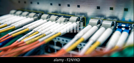 Fiber optical switch with connected FC cables in server room. Cross balance effect applied Stock Photo