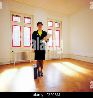 Real estate agent standing in an empty sunny room Stock Photo