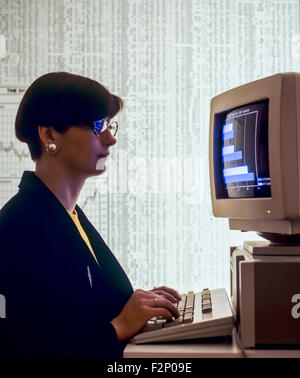 Businesswoman studying statistics graph on computer and stock market composite transactions listing background Stock Photo