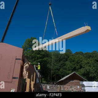 Construction workers install roof rafters on Leed Platinum Common Ground High School building. Stock Photo