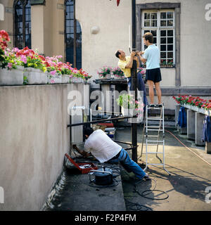 Telecom engineers installing a cellular telephone relay on ancient building, France Stock Photo