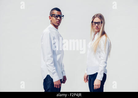 Portrait of stylish young couple wearing matching clothes in front of white background Stock Photo