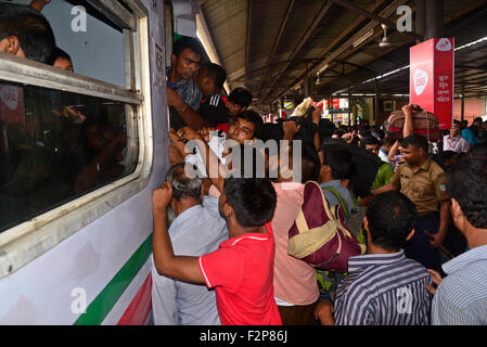 Dhaka, Bangladesh. 22nd September, 2015. Bangladeshi Muslims make space for themselves on the roof of an overcrowded train to head home ahead of Eid-Ul-Adha as others wait at a railway station in Dhaka. On September 22, 2015 Throngs of people making their way home to join families for the upcoming Eid-Ul-Adha festival began filling up Dhaka's trains. Millions of Bangladeshis are expected to travel home to celebrate the festival. Credit:  Mamunur Rashid/Alamy Live News Stock Photo