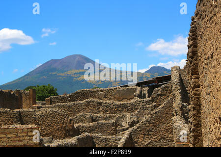 View of ruins in the old city of Pompeii, Italy with Mount Vesuvius in the background Stock Photo