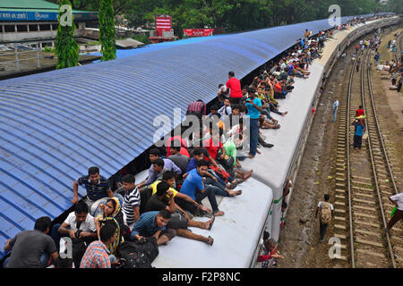 Dhaka, Bangladesh. 22nd September, 2015. Bangladeshi Muslims make space for themselves on the roof of an overcrowded train to head home ahead of Eid-Ul-Adha as others wait at a railway station in Dhaka. On September 22, 2015 Throngs of people making their way home to join families for the upcoming Eid-Ul-Adha festival began filling up Dhaka's trains. Millions of Bangladeshis are expected to travel home to celebrate the festival. Credit:  Mamunur Rashid/Alamy Live News Stock Photo