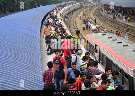 Dhaka, Bangladesh. 22nd September, 2015. Bangladeshi Muslims make space for themselves on the roof of an overcrowded train to head home ahead of Eid-Ul-Adha as others wait at a railway station in Dhaka. On September 22, 2015 Throngs of people making their way home to join families for the upcoming Eid-Ul-Adha festival began filling up Dhaka's trains. Millions of Bangladeshis are expected to travel home to celebrate the festival. Credit:  Mamunur Rashid/Alamy Live News Stock Photo