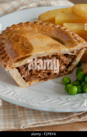 Steak or beef pie with chips or fries and green peas Stock Photo