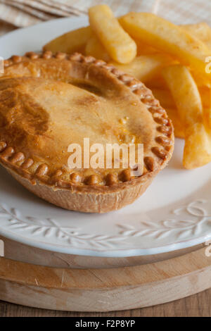 Savoury meat pie with chips or French fries Stock Photo