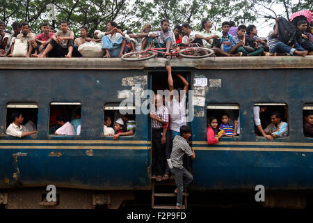 Dhaka, Bangladesh. 22nd September, 2015. Bangladeshi Muslims make space for themselves on the roof of an overcrowded train to head home ahead of Eid-Ul-Adha as others wait at a railway station in Dhaka. On September 22, 2015 Throngs of people making their way home to join families for the upcoming Eid-Ul-Adha festival began filling up Dhaka's trains. Millions of Bangladeshis are expected to travel home to celebrate the festival. Credit:  Mamunur Rashid/Alamy Live News Stock Photo