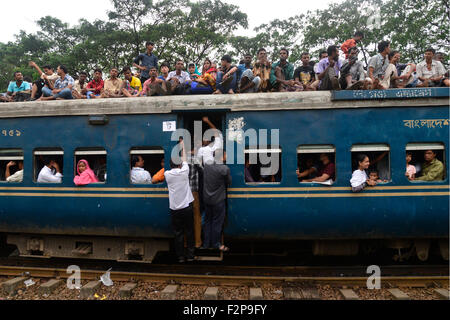 Dhaka, Bangladesh. 22nd September, 2015. Bangladeshi Muslims make space for themselves on the roof of an overcrowded train to head home ahead of Eid-Ul-Adha as others wait at a railway station in Dhaka. On September 22, 2015 Throngs of people making their way home to join families for the upcoming Eid-Ul-Adha festival began filling up Dhaka's trains. Millions of Bangladeshis are expected to travel home to celebrate the festival. Credit:  Mamunur Rashid/Alamy Live News Stock Photo