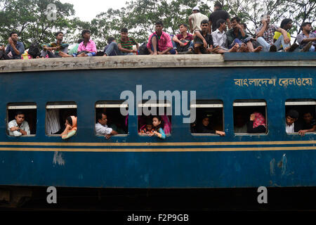 Dhaka, Bangladesh. 22nd September, 2015. Bangladeshi Muslims make space for themselves on the roof of an overcrowded train to head home ahead of Eid-Ul-Adha as others wait at a railway station in Dhaka. On September 22, 2015 Throngs of people making their way home to join families for the upcoming Eid-Ul-Adha festival began filling up Dhaka's trains. Millions of Bangladeshis are expected to travel home to celebrate the festival. Credit:  Mamunur Rashid/Alamy Live News Stock Photo