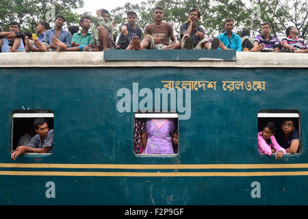 Dhaka, Bangladesh. 22nd September, 2015. Bangladeshi Muslims make space for themselves on the roof of an overcrowded train to head home ahead of Eid-Ul-Adha as others wait at a railway station in Dhaka. On September 22, 2015 Throngs of people making their way home to join families for the upcoming Eid-Ul-Adha festival began filling up Dhaka's trains. Millions of Bangladeshis are expected to travel home to celebrate the festival. Credit:  Mamunur Rashid/Alamy Live News Stock Photo