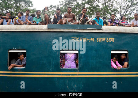 Dhaka, Bangladesh. 22nd September, 2015. Bangladeshi Muslims make space for themselves on the roof of an overcrowded train to head home ahead of Eid-Ul-Adha as others wait at a railway station in Dhaka. On September 22, 2015 Throngs of people making their way home to join families for the upcoming Eid-Ul-Adha festival began filling up Dhaka's trains. Millions of Bangladeshis are expected to travel home to celebrate the festival. Credit:  Mamunur Rashid/Alamy Live News Stock Photo