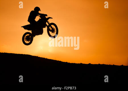 motorcycle silhouette are jumping on sunset Stock Photo