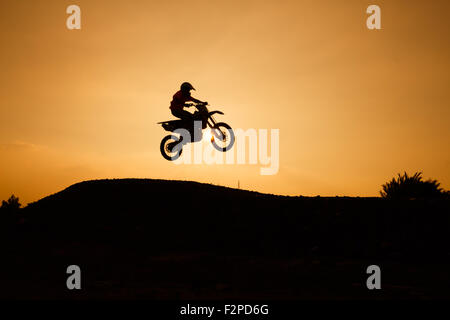 motorcycle silhouette are jumping on sunset Stock Photo