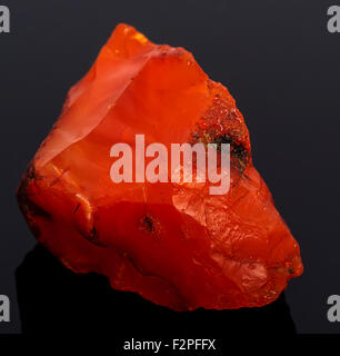 Rough red carnelian rock isolated on black background Stock Photo