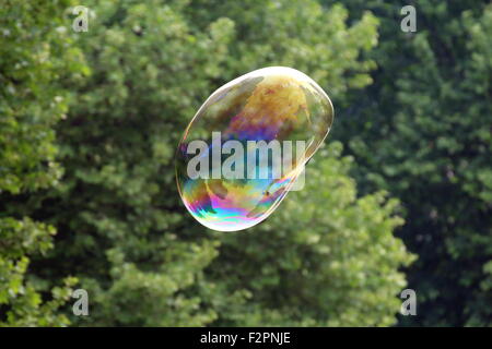 Giant soap bubbles created with ropes and sticks in a park Stock Photo
