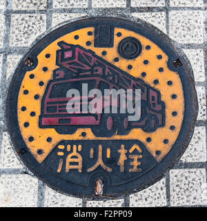 Round manhole cover in a path with the words 'Fire Hydrant' in Japanese on it Stock Photo