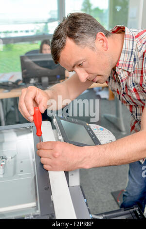 Man trying to repair the office printer Stock Photo