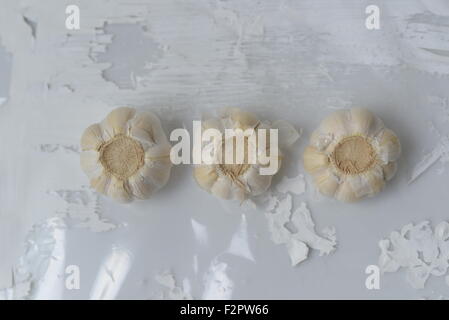 Three Bulbs of garlic on a white worktop Stock Photo
