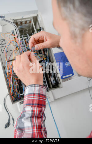 Electrican connecting fuse box Stock Photo