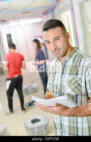 Builder taking notes as he works Stock Photo