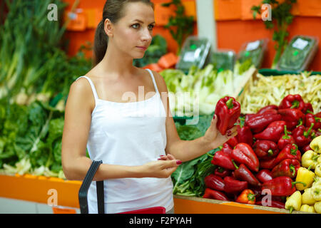 Young beautiful woman shopping in a supermarket in the department of fruit and vegetables Stock Photo