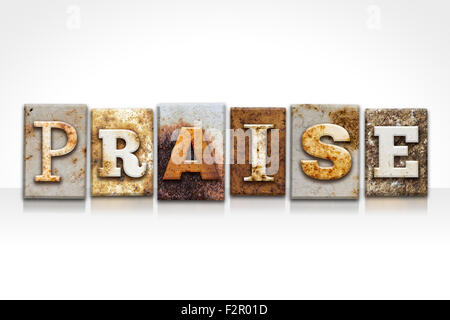 The word 'PRAISE' written in rusty metal letterpress type isolated on a white background. Stock Photo