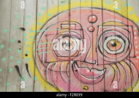 Detail of street art. Colourful graffiti of a sunny smiling face painted on a window shutter by the artist known as Loko. Montpellier, South of France. Stock Photo