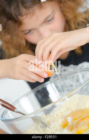 Child breaking egg into bowl