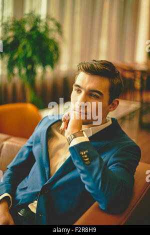 Young handsome businessman sitting on sofa Stock Photo