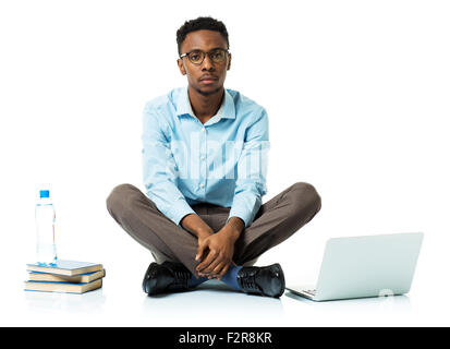 Serious african american college student with laptop, books and bottle of water sitting on white background Stock Photo