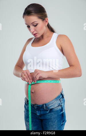 Pregnant woman measuring pregnant belly isolated on a white background Stock Photo