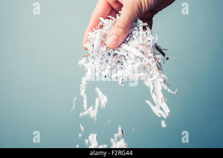 Hand is holding a bunch of shredded paper Stock Photo