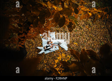 wedding couple lying under a tree Stock Photo