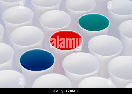 White paper cups on a white background. Some cups have colored liquid in them Stock Photo