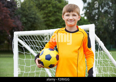 Portrait Of Goal Keeper Holding Ball On School Soccer Pitch Stock Photo