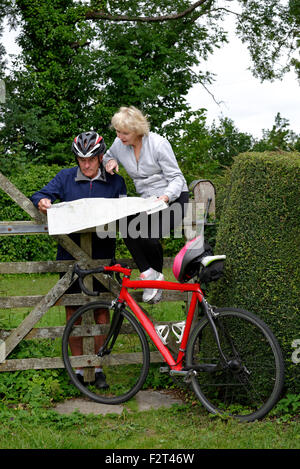 Elderly couple map reading during a cycle ride in the countryside Stock Photo