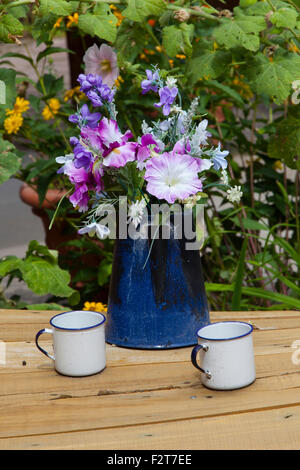 Coffee pot filled with flowers sits on a table in Taos, New Mexico Stock Photo
