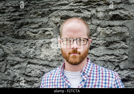 A man in his 30s aganst a stone wall Stock Photo