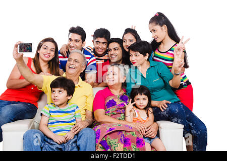 indian group Joint Family sitting sofa Mobile Phone Picture Self-portrait Stock Photo