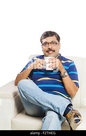 1 indian Adult Man Sitting Sofa drinking tea Stock Photo