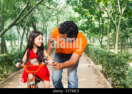 2 indian Father and Kids Daughter park Riding Bicycle Stock Photo