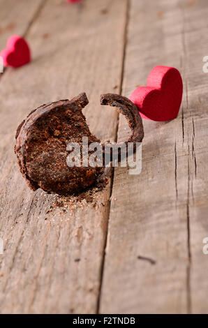 Rusty padlock with a red heart shape on a wooden background Stock Photo