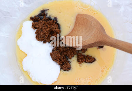 Close-up mixing muscovado sugar and caster sugar into beaten eggs for pie filling Stock Photo