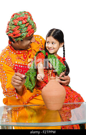 2 indian Rajasthani Villager father and daughter Piggy Bank Saving money Stock Photo